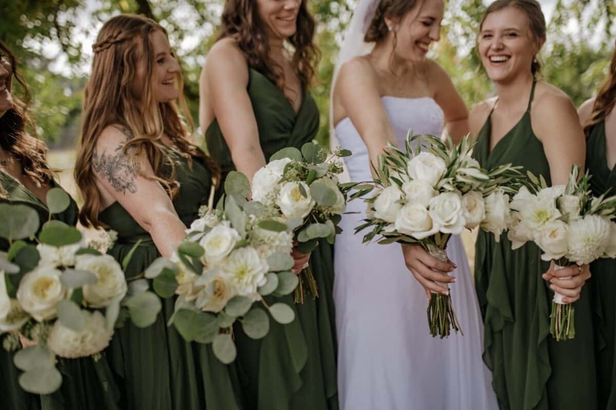 Bridesmaids In Soft and Neutral Dress while holding flower bouquets