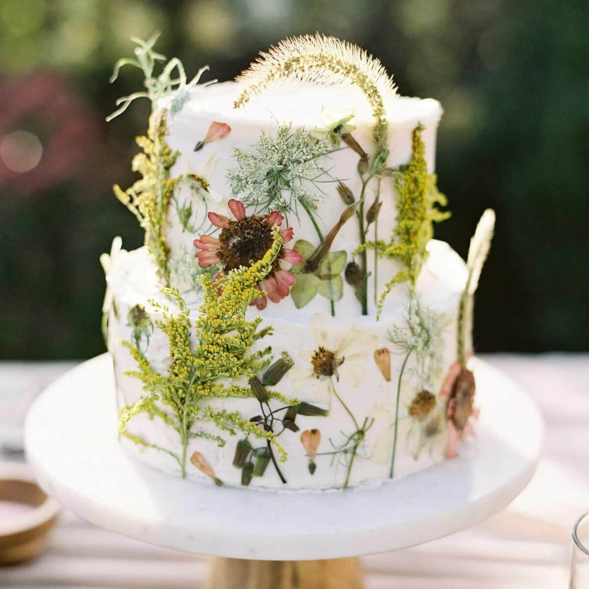 Gorgeous Yummy Wedding Cake with 2-tiered design, white buttercream and edible greenery and floral topper