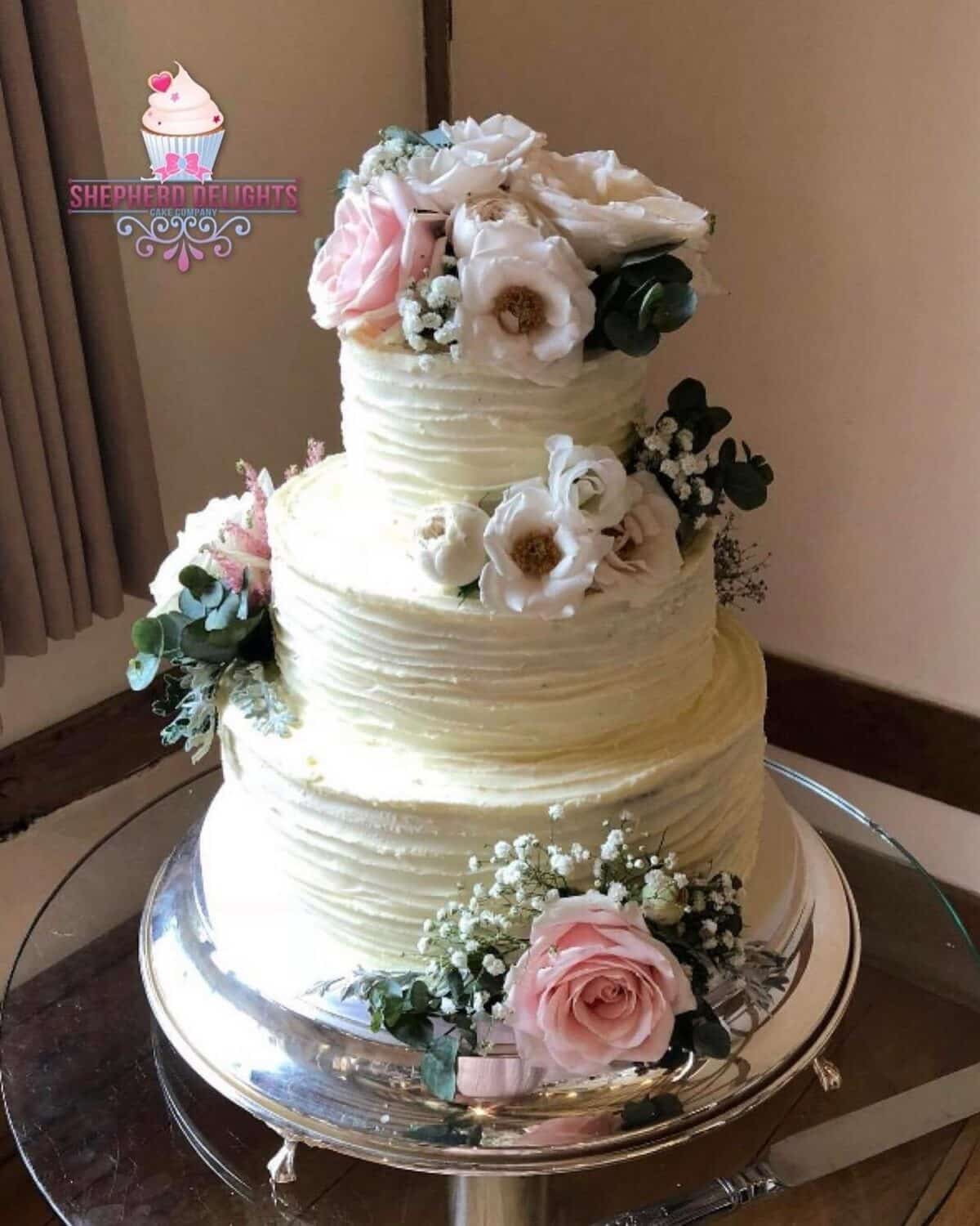 White Buttercream wedding cake with flora topper