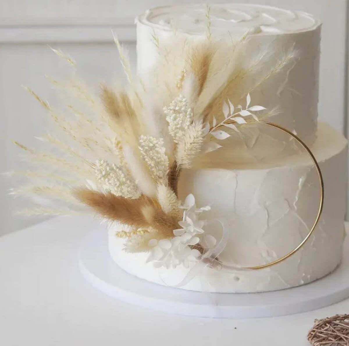 Aesthetic Boho Wedding Cake with white frosting and pampas grass decorations