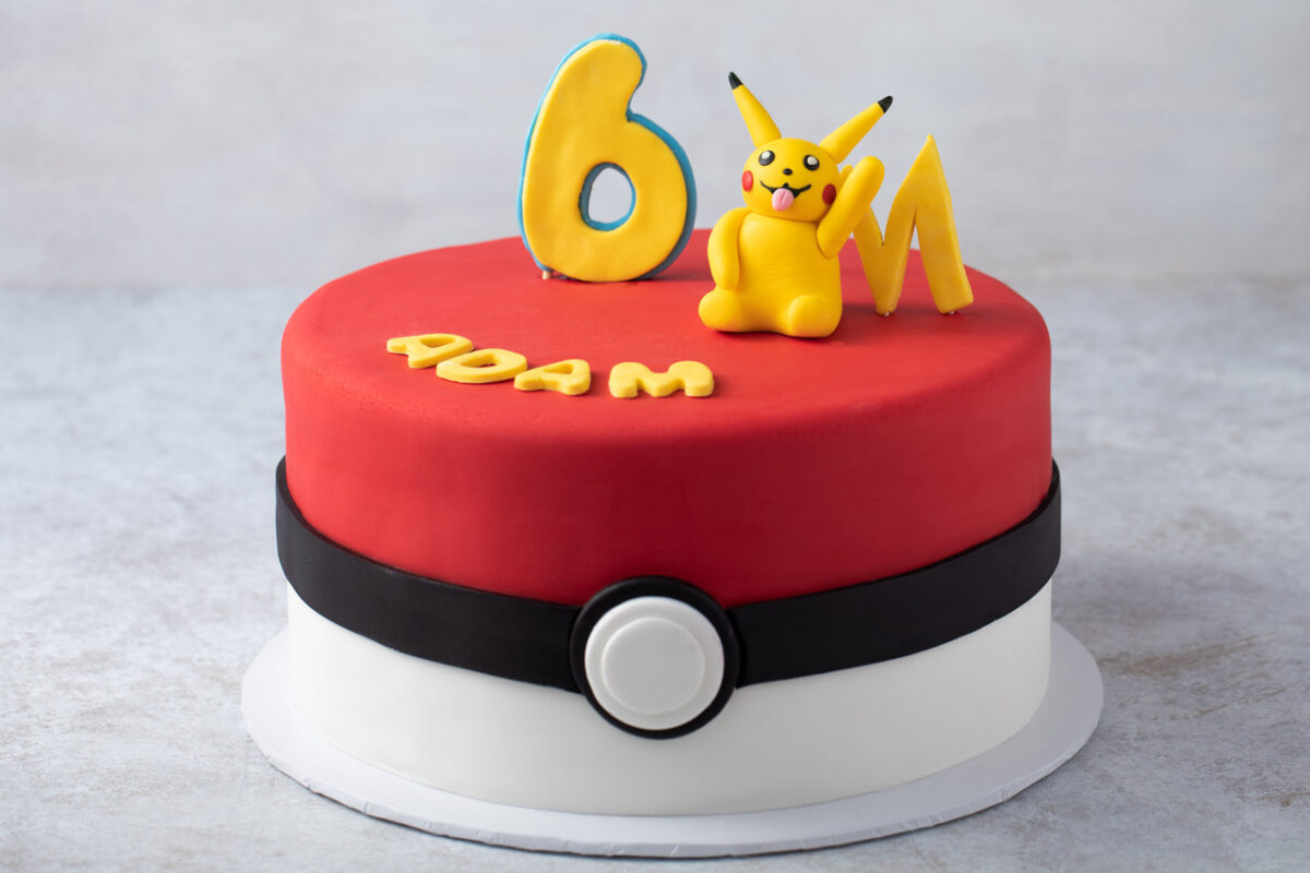 Pokemon Ball Cake with red and white frosting, and edible Pikachu