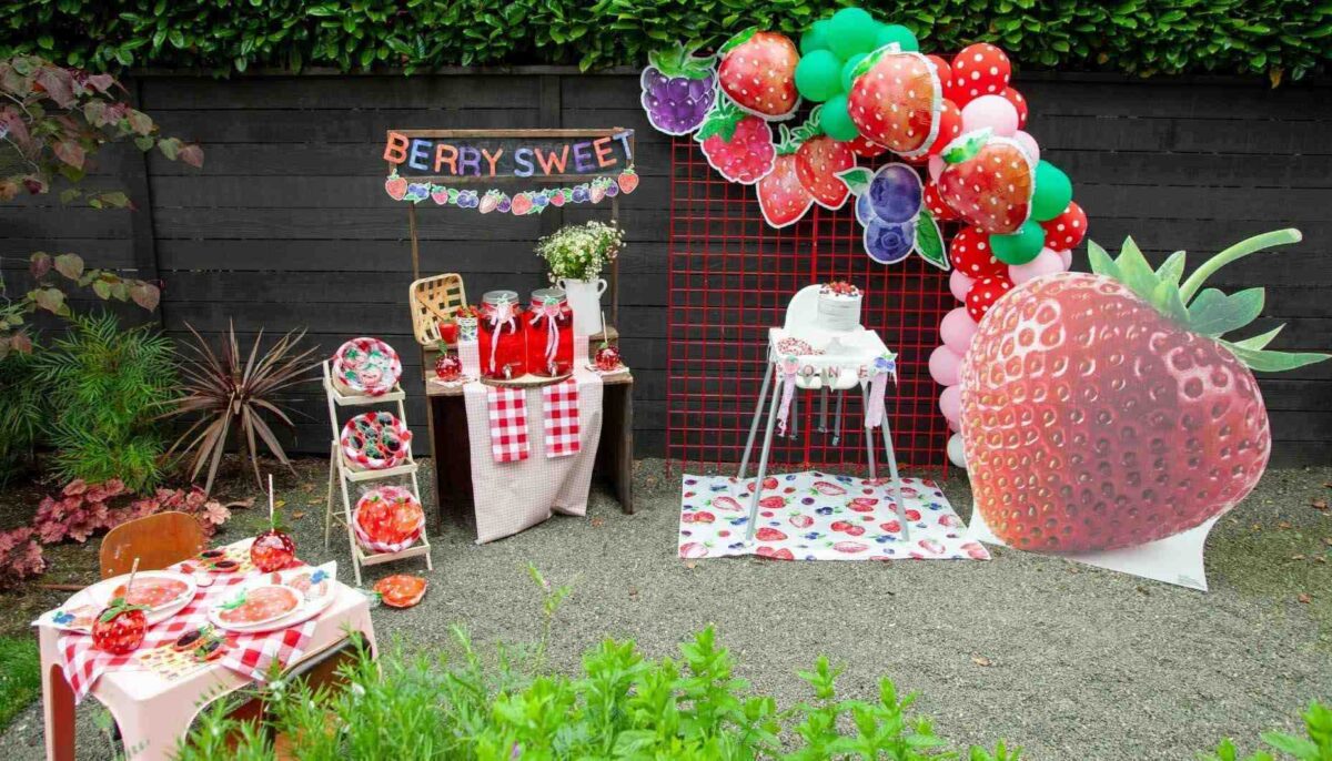 Backyard Strawberry Birthday Party with Berry Sweet garland and inflatable Strawberry balloons